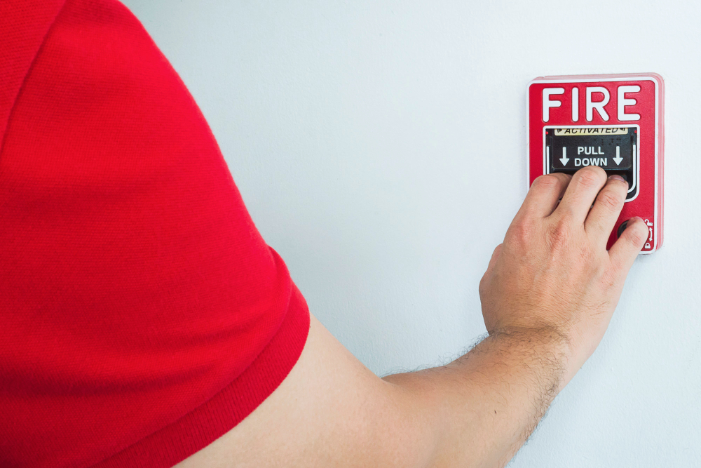 Seseorang yang menekan tombol fire alarm